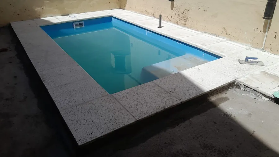 Piscina de fibra con cascada decorativa nocturna en Tucumán